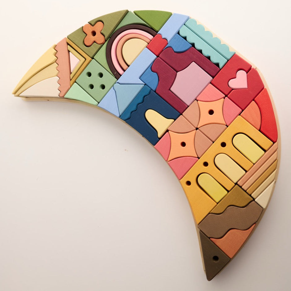 A colorful wooden geometric puzzle piece set arranged in a crescent or moon-like shape on a plain off-white background.
